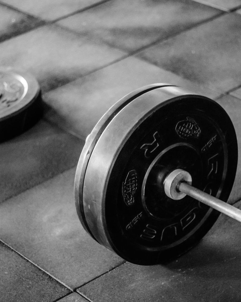 Athletic equipment lying on a clean floor in a sunlit studio.